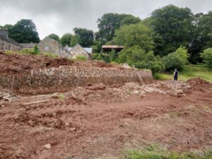 Bare earth during restoration works on the ha-ha, a type of sunken stone wall.