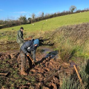 Photo of two people working on a leaky dam