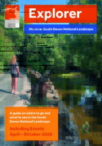 Explorer brochure front cover with image of a lady with a black dog on a lead on a bridge with views of the water and trees. The dog is on his hind legs looking over the bridge to the water.