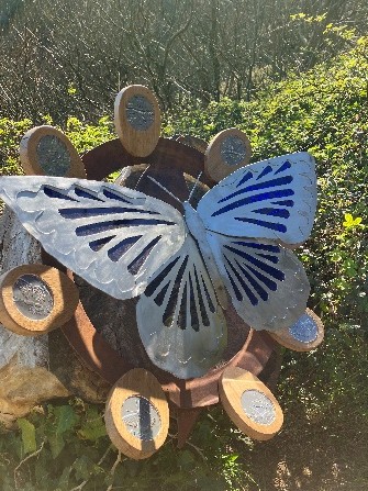 Large metalwork sculpture of a Silver-studded Blue butterfly surrounded by vegetation