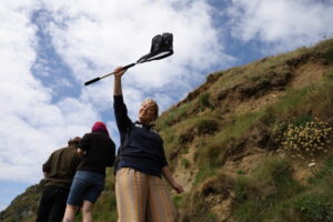an image of a person smiling at the camera holding a net up in the air